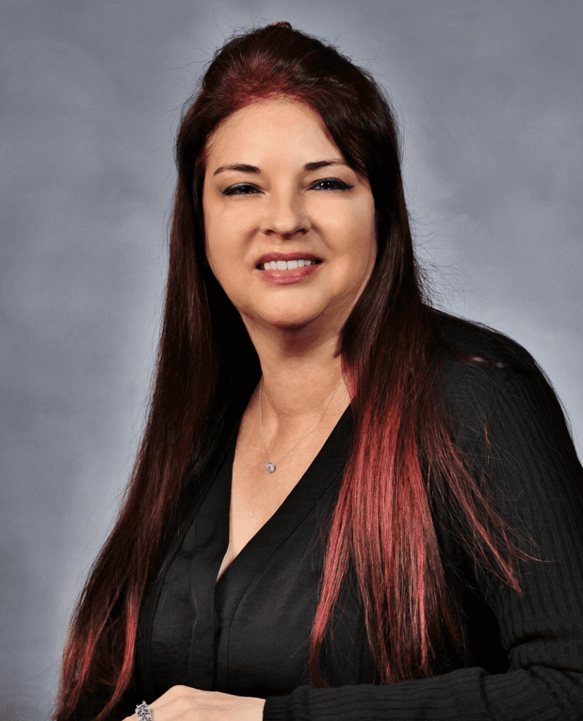 Andrea Block wearing a black dress with a gray background.