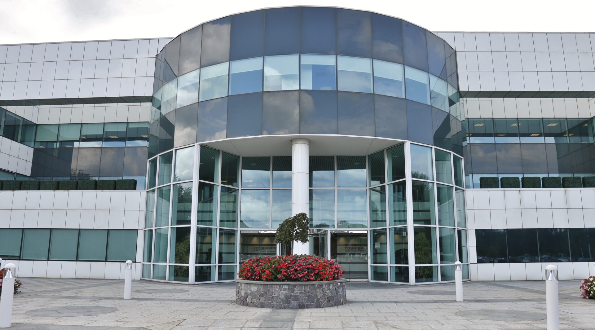 Modern office building entrance with flowers.